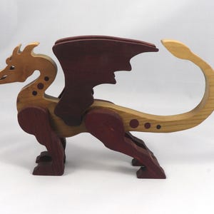 Handmade wooden dragon figurine made from contrasting hardwoods with a light natural wood body and head paired with rich dark reddish-brown wings, legs, and horns.