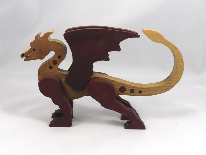 Handmade wooden dragon figurine made from contrasting hardwoods with a light natural wood body and head paired with rich dark reddish-brown wings, legs, and horns.