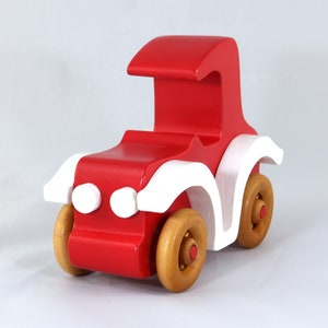 Handmade wooden toy car, vintage style red Model T Coupe by Odin's Toy Factory. Two-tone red and white acrylic paint with spoked wooden wheels finished in amber shellac. Approximate dimensions: 5 inches long, 4 inches high, 2.5 inches wide. Part of Bad Bob’s Custom Motors Collection. Crafted from natural wood using traditional woodworking tools. Handmade in Tallahassee, Florida, USA.