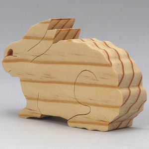 This is an unfinished wooden Rabbit cutout from solid wood using traditional woodworking techniques. Sanded smooth and ready to paint, stain, or customize. Freestanding design for small hands, toddlers, young children, crafters, collectors, and display. I take custom orders for any animal, quantity, and mix — including large ornament orders. Mix and match, request a different size, or send a drawing or pattern. Handmade by Odin's Toy Factory in Tallahassee, Florida, USA.
