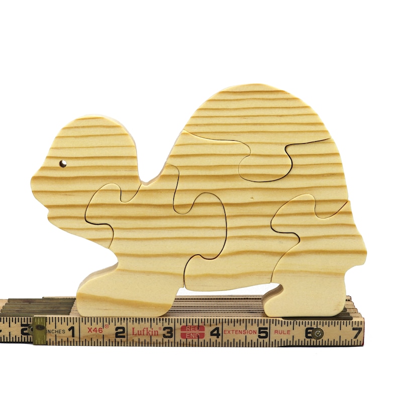 Handmade wooden turtle puzzle with 5 simple interlocking pieces. Freestanding 5-piece wooden puzzle. Approximate dimensions: 5 inches high by 7.25 inches long by 0.75 inches thick. Finished with mineral oil and beeswax blend. Handcrafted in Tallahassee, Florida, USA, using natural wood. Unique wood grain color and knot variations. Odin’s Toy Factory.