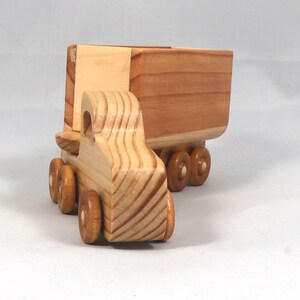 Handmade wooden toy tractor trailer semi truck finished with clear shellac. Crafted from natural wood using traditional woodworking tools. Approximate size 7 inches long. Made in Tallahassee, Florida, USA from Odin's Toy Factory Play Pal Collection.
