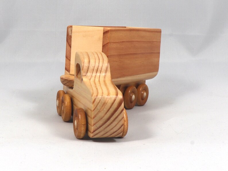 Handmade wooden toy tractor trailer semi truck finished with clear shellac. Crafted from natural wood using traditional woodworking tools. Approximate size 7 inches long. Made in Tallahassee, Florida, USA from Odin's Toy Factory Play Pal Collection.