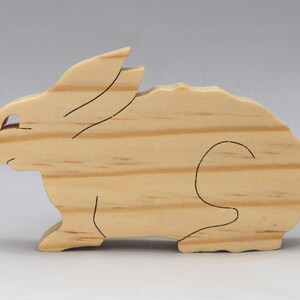 This is an unfinished wooden Rabbit cutout from solid wood using traditional woodworking techniques. Sanded smooth and ready to paint, stain, or customize. Freestanding design for small hands, toddlers, young children, crafters, collectors, and display. I take custom orders for any animal, quantity, and mix — including large ornament orders. Mix and match, request a different size, or send a drawing or pattern. Handmade by Odin's Toy Factory in Tallahassee, Florida, USA.