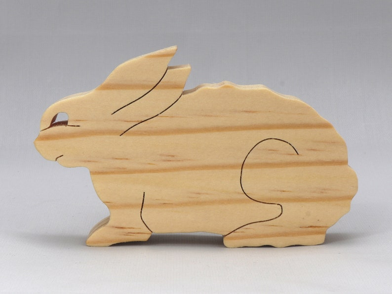 This is an unfinished wooden Rabbit cutout from solid wood using traditional woodworking techniques. Sanded smooth and ready to paint, stain, or customize. Freestanding design for small hands, toddlers, young children, crafters, collectors, and display. I take custom orders for any animal, quantity, and mix — including large ornament orders. Mix and match, request a different size, or send a drawing or pattern. Handmade by Odin's Toy Factory in Tallahassee, Florida, USA.
