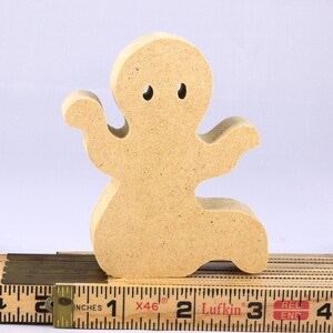 A handmade, unpainted wooden ghost cutout stands upright on a white background. The light-colored solid wood figure has a rounded head with two circular eye cutouts, raised wavy arms, and a curved wavy base, ready for painting or crafting.