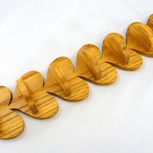 Handmade heart-shaped shelf crafted from reclaimed oak hardwood and finished with polyurethane. Perfect for displaying small items and adding rustic charm to home decor.