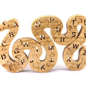 Hand-cut Alphabet Snake Puzzle made from premium hardwood, finished with mineral oil and beeswax for durability. Each of the 26 pieces represents a letter, promoting alphabet learning and essential skills development in kids through play.