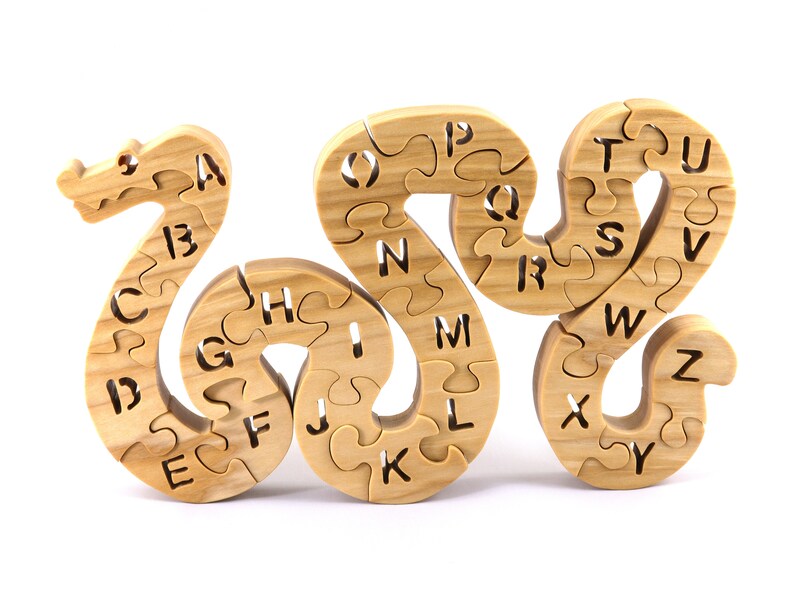 Hand-cut Alphabet Snake Puzzle made from premium hardwood, finished with mineral oil and beeswax for durability. Each of the 26 pieces represents a letter, promoting alphabet learning and essential skills development in kids through play.