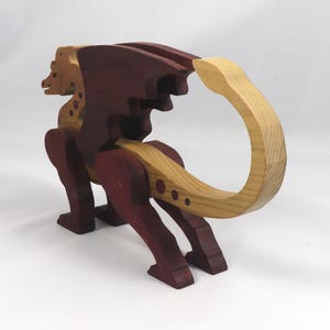Handmade wooden dragon figurine made from contrasting hardwoods with a light natural wood body and head paired with rich dark reddish-brown wings, legs, and horns.