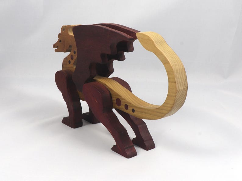 Handmade wooden dragon figurine made from contrasting hardwoods with a light natural wood body and head paired with rich dark reddish-brown wings, legs, and horns.