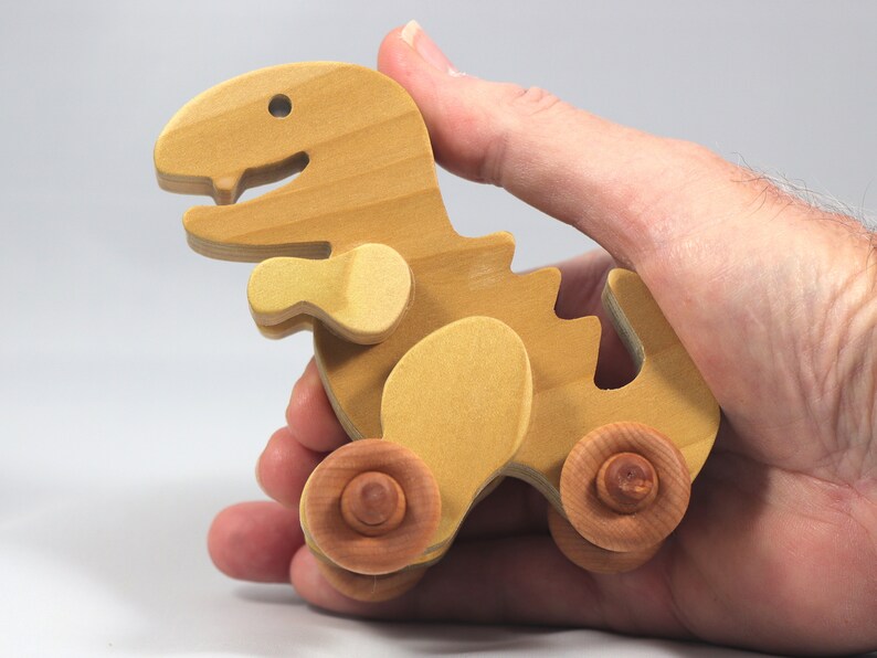 Handmade wooden push toy Tyrannosaurus Rex dinosaur made from select grade hardwoods and finished with a non-toxic coating.