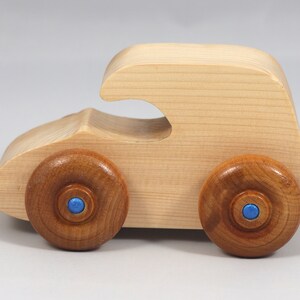 Handmade wooden toy car. The body is finished with clear shellac, and the wheels are finished with amber shellac. The hubs are painted with metallic sapphire blue trim.