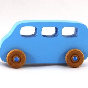 A Handmade wood toy mini van hand-painted baby blue with metallic sapphire blue trim and wheels finished with nonmarring amber shellac from my Play Pall Collection.