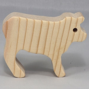 Handmade unfinished wooden toy baby calf cutout, unpainted and ready to paint, freestanding farm animal figure from Odin's Toy Factory’s  Itty Bitty Animal Collection. Handcrafted in Tallahassee, Florida, USA, using reclaimed natural wood offcuts. Perfect for imaginative play, stacking, collectors, and crafting.