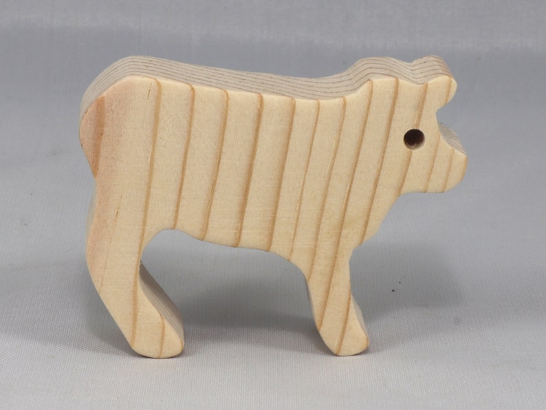 Handmade unfinished wooden toy baby calf cutout, unpainted and ready to paint, freestanding farm animal figure from Odin's Toy Factory’s  Itty Bitty Animal Collection. Handcrafted in Tallahassee, Florida, USA, using reclaimed natural wood offcuts. Perfect for imaginative play, stacking, collectors, and crafting.