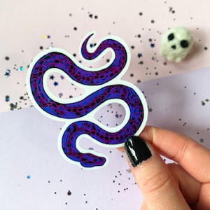 May include: A sticker of a purple and blue snake with a white outline. The snake is curled up in a coil.