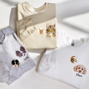 Può includere: Tre felpe con toppe ricamate personalizzate di animali domestici. La prima felpa è grigia con una toppa di cane bianco e nero che dice "Spotty". La seconda felpa è beige con una toppa di gatto e una toppa di gatto arancione più piccola. La terza felpa è bianca con una toppa di cane marrone che dice "Maxie".