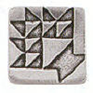 May include: Square, silver-toned metal button with a geometric design. The design features a pattern of triangles and squares, creating a textured appearance. The button is likely used for decorative purposes on clothing or accessories.