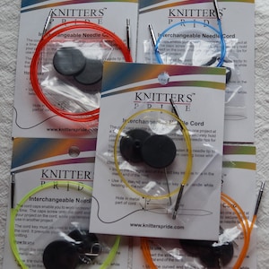 May include: Four packages of interchangeable needle cords for knitting. Each package features a different color cord: red, blue, yellow, and orange. The packages include instructions on how to use the cords and a metal key for tightening the cords.