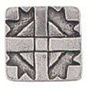 May include: Square, silver-colored metal button with a raised geometric design. The design features a central cross shape with arrow-like elements in each quadrant. The button has a slightly textured surface and rounded edges.