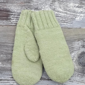 May include: A pair of green knitted mittens. The mittens are made of a soft, warm material and have a simple, classic design.