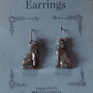 May include: A pair of pewter wolf earrings with surgical steel posts and wires. The earrings are handcrafted by Danforth Pewterers, Ltd. in Middlebury, Vermont.