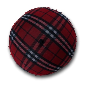 May include: A round, red plaid hat with black and white stripes. The hat has a small, black button on top and a ruffled edge. The plaid pattern is a classic design, suitable for various occasions.