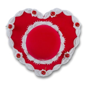 May include: A red heart-shaped hat with white trim and red cherries around the edge. The hat has a white and red center with a red velvet top.