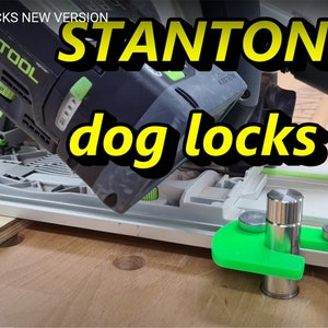 May include: A close-up of a green and black power tool with a green and black vacuum hose attached. The tool is labelled "EST00L" and is positioned over a green and silver track with a green and silver dog lock. The text "STANTON dog locks" is superimposed on the image.