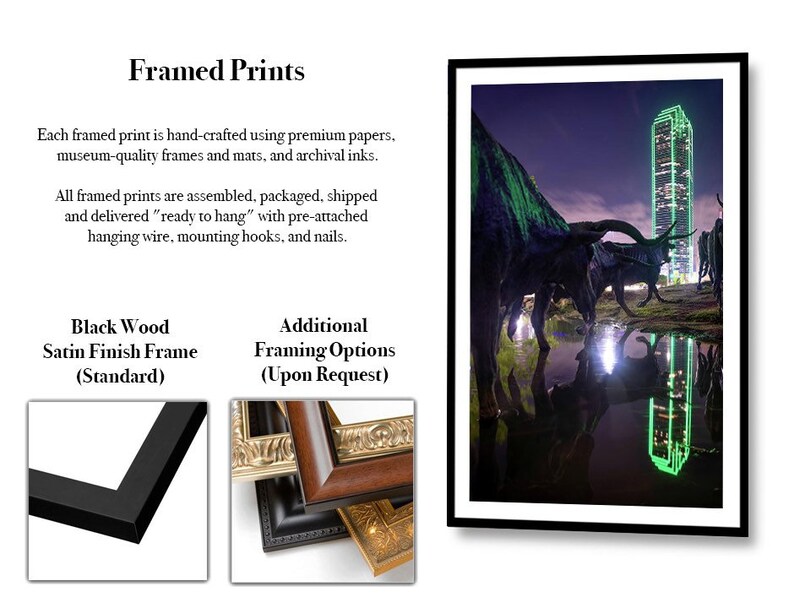 May include: Framed print of a night cityscape with a tall skyscraper and a group of bronze statues of longhorns reflected in a puddle of water. The print is available in a black wood satin finish frame or other framing options.