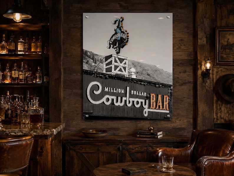 May include: A rectangular wall art print featuring a black and white photograph of the Million Dollar Cowboy Bar sign. The image displays a neon cowboy on a bucking horse atop a roof, with the text Million Dollar Cowboy Bar in illuminated letters.