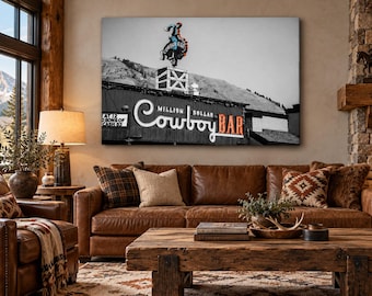 May include: A rectangular wall art print featuring a black and white photograph of the Million Dollar Cowboy Bar sign. The image displays a neon cowboy on a bucking horse atop a building, with the text Million Dollar Cowboy Bar clearly visible.