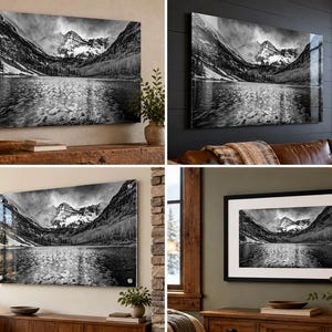 May include: A black and white landscape wall art print featuring a mountain range reflected in a calm lake. The image captures jagged peaks, a dense forest, and rippling water, presented in various display styles including framed and acrylic.