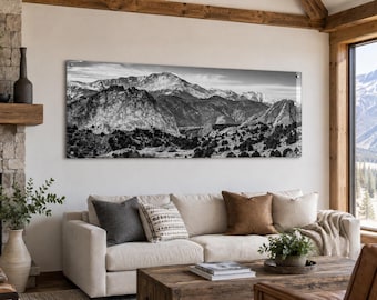 May include: A panoramic black and white wall art print featuring a rugged mountain range with snow-capped peaks and rocky foothills. The landscape displays high contrast textures of stone and sparse vegetation, mounted horizontally on a light wall.