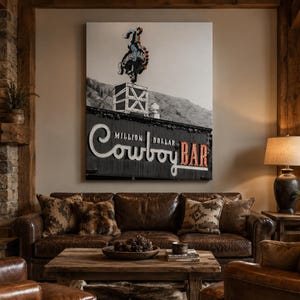 May include: A large rectangular wall art print featuring a black and white photograph of the Million Dollar Cowboy Bar sign. The image displays a neon cowboy on a bucking horse atop a building, with the text Million Dollar Cowboy Bar below.