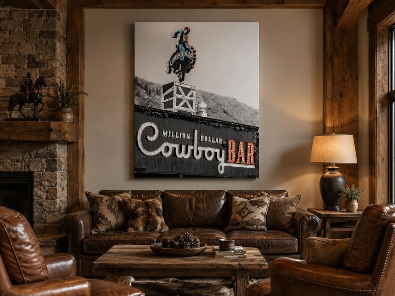 May include: A large rectangular wall art print featuring a black and white photograph of the Million Dollar Cowboy Bar sign. The image displays a neon cowboy on a bucking horse atop a building, with the text Million Dollar Cowboy Bar below.