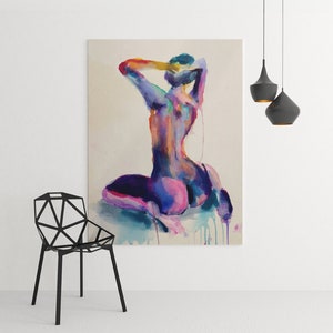 Large abstract watercolor nude painting by Nick Horvath displayed in a modern minimalist room with geometric black chair and pendant lights. Features a kneeling female figure in bold purples, pinks, and blues with expressive drips. Striking, sensual wall art.