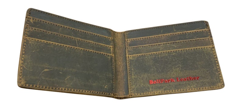 Pu&ograve; includere: Un portafoglio in pelle marrone con pi&ugrave; slot per carte e un portafoglio per banconote. Il portafoglio &egrave; aperto e l'interno &egrave; visibile. Il nome del marchio "BallPark Leather" &egrave; stampato in rosso sul lato destro del portafoglio.