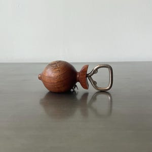 May include: A wooden bottle opener shaped like a lemon with a silver metal opener.