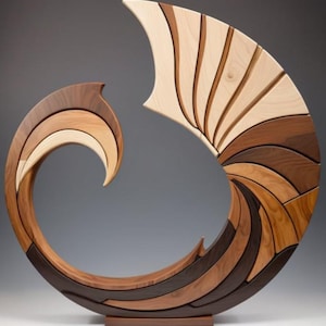 May include: A wooden sculpture with a swirling, wave-like design. The sculpture is made of various shades of wood, including light beige, medium brown, and dark brown. It has a curved, open form and sits on a rectangular base. The piece is a decorative art object.