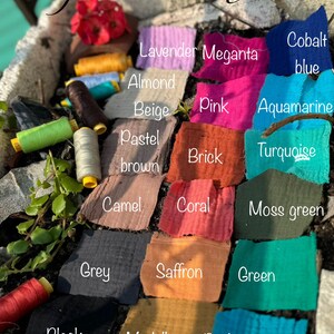 May include: A display of colorful cotton gauze fabric swatches in various shades, including pink, blue, green, and brown. The image also features spools of thread and the text "Gauze Cotton."