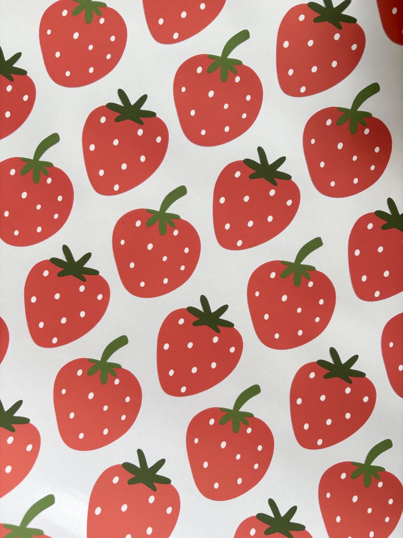 May include: A white background with a repeating pattern of red strawberries with white seeds. The strawberries have green leaves.