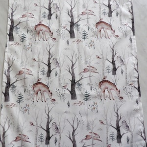 Könnte beinhalten: Weißer Stoff mit einem sich wiederholenden Muster einer winterlichen Waldszene. Das Design umfasst Hirsche, Kaninchen, Eulen und Vögel zwischen kahlen Bäumen. Die Farbpalette ist weich, mit gedämpften Brauntönen, Grautönen und Grüntönen.