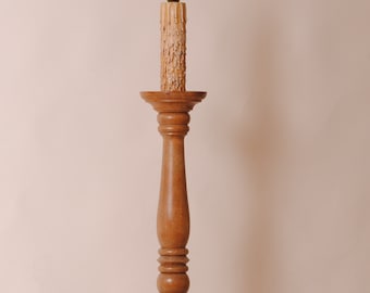 May include: A wooden floor lamp with a candle-shaped light bulb and a round base.