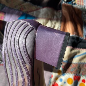 Pu&ograve; includere: Scarpe con tacco in rete viola con tacco a blocco. Il tacco &egrave; rivestito in tessuto testurizzato.