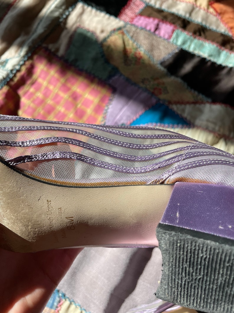 Pu&ograve; includere: Scarpe con tacco in rete viola con suola in gomma nera. Le scarpe hanno un'etichetta che recita "Made in Upper China" e "WM".