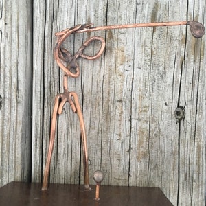 Figura de arte en cobre de un golfista golpeando la pelota desde el tee