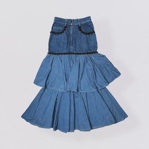 Pode incluir: Uma saia de ganga azul com tr&ecirc;s camadas de babados. A camada superior &eacute; uma saia de ganga com guarni&ccedil;&atilde;o preta. A saia &eacute; de estilo casual.