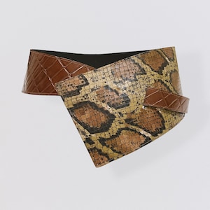 Könnte beinhalten: Ein brauner und grüner Gürtel mit Schlangenhautmuster und einem Krokodilprägemuster.